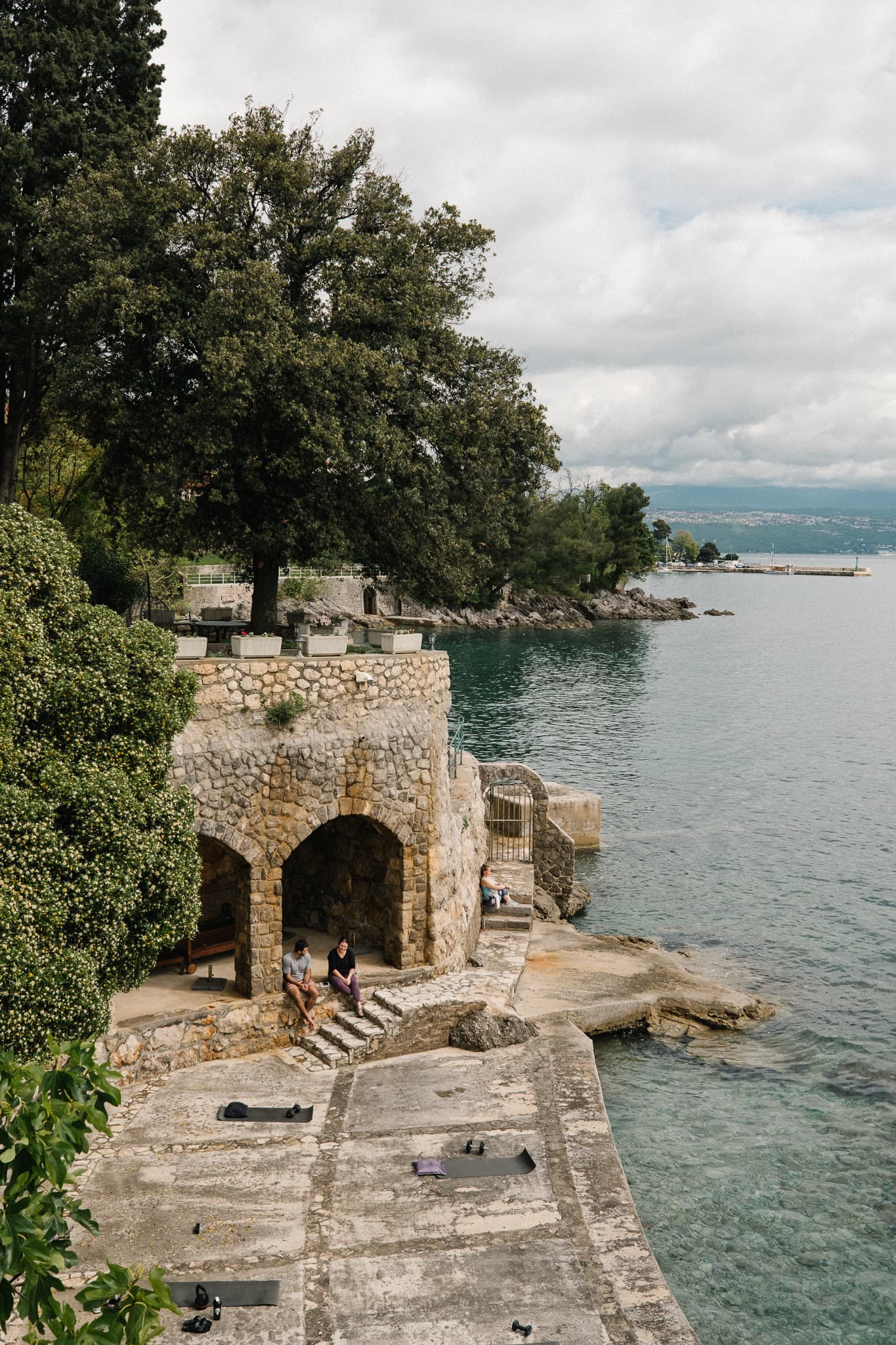 Stone arches and a lower terrace set into the coastline.